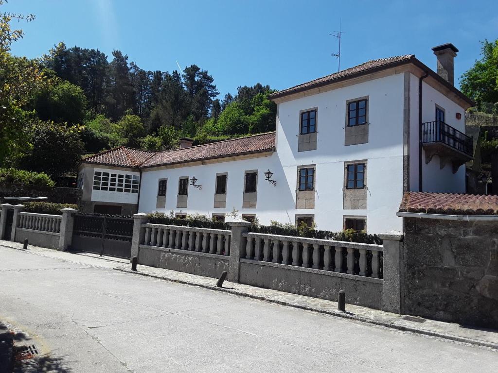 a white house with a fence in front of it at Casa Pontevella in Amés