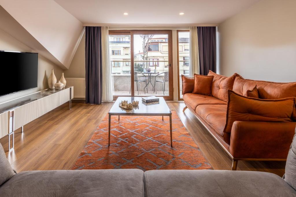a living room with a brown couch and a table at BayMari Suites Plus Florya in Istanbul