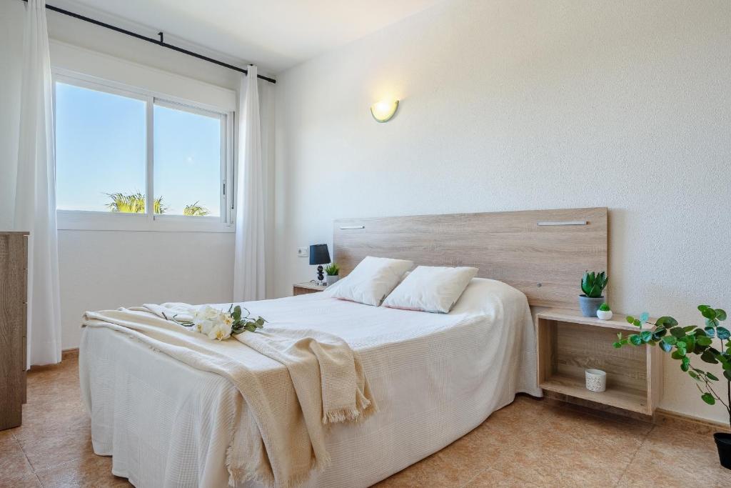 ラ・ピネーダにあるAlea Rentals - Los Riscosのベッドルーム1室(白いシーツが敷かれた大型ベッド1台、窓付)