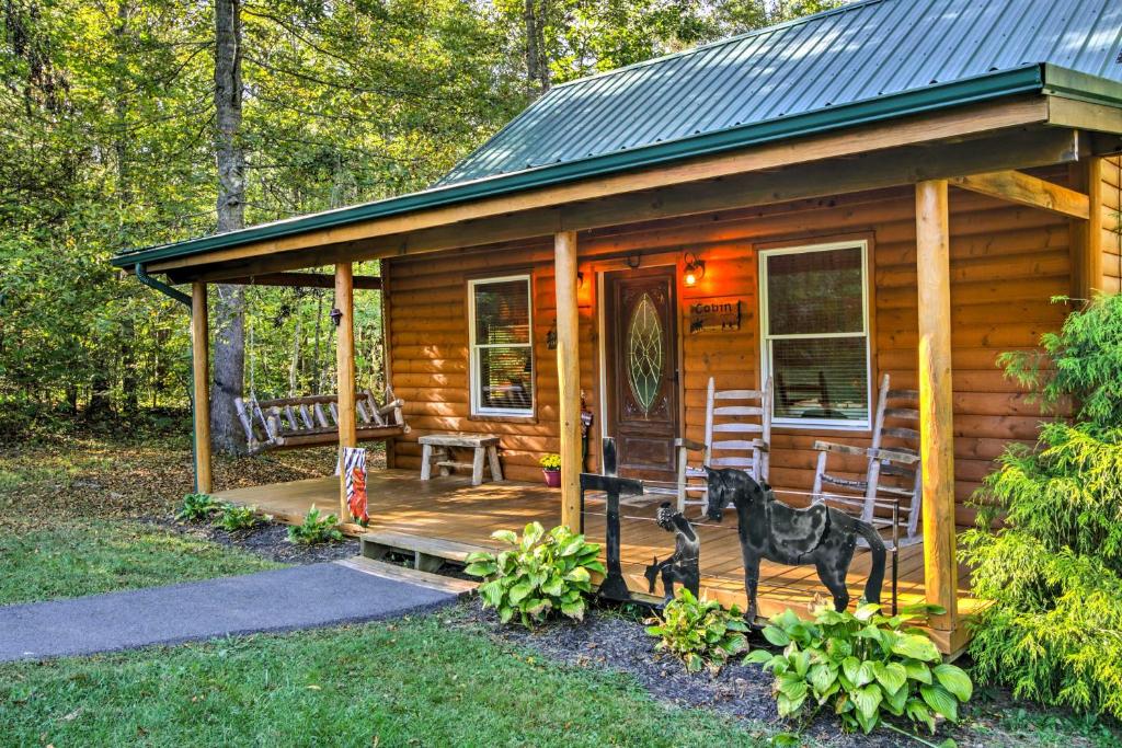 une cabane en bois avec un cheval devant elle dans l'établissement Smoky Mountain Rustic Log Cabin with Furnished Patio, à Cosby