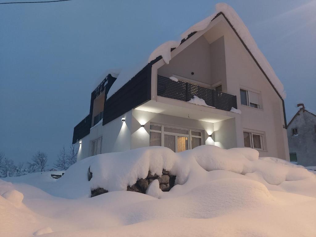 a house covered in snow in front of it at Elegant Inn Gospić in Gospić