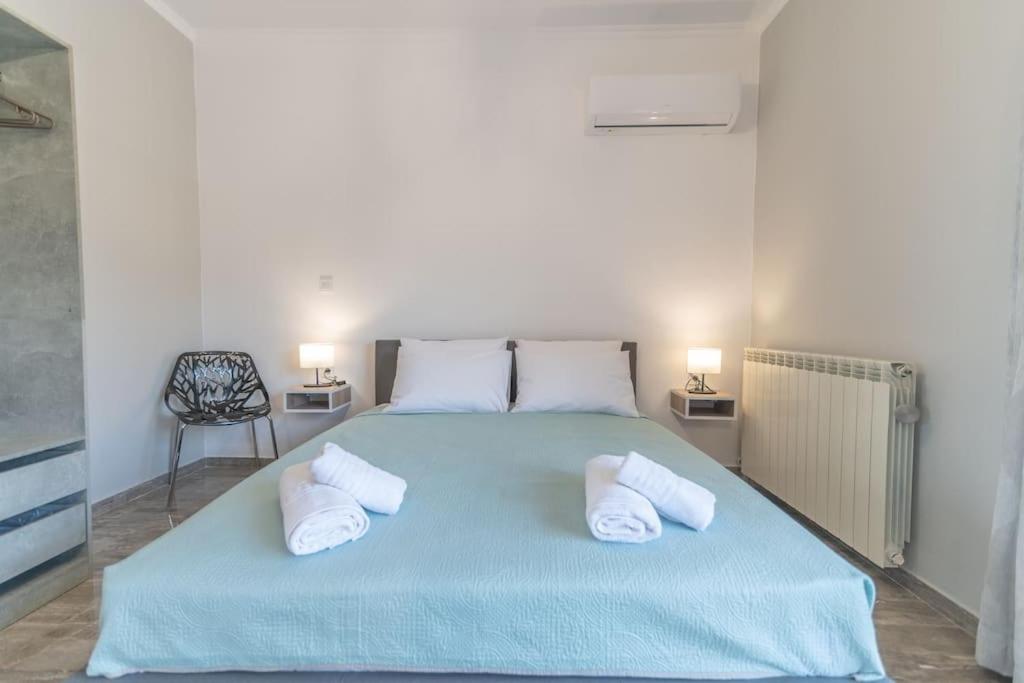 a bedroom with a blue bed with two pillows at Kos Helios House in Psalidi