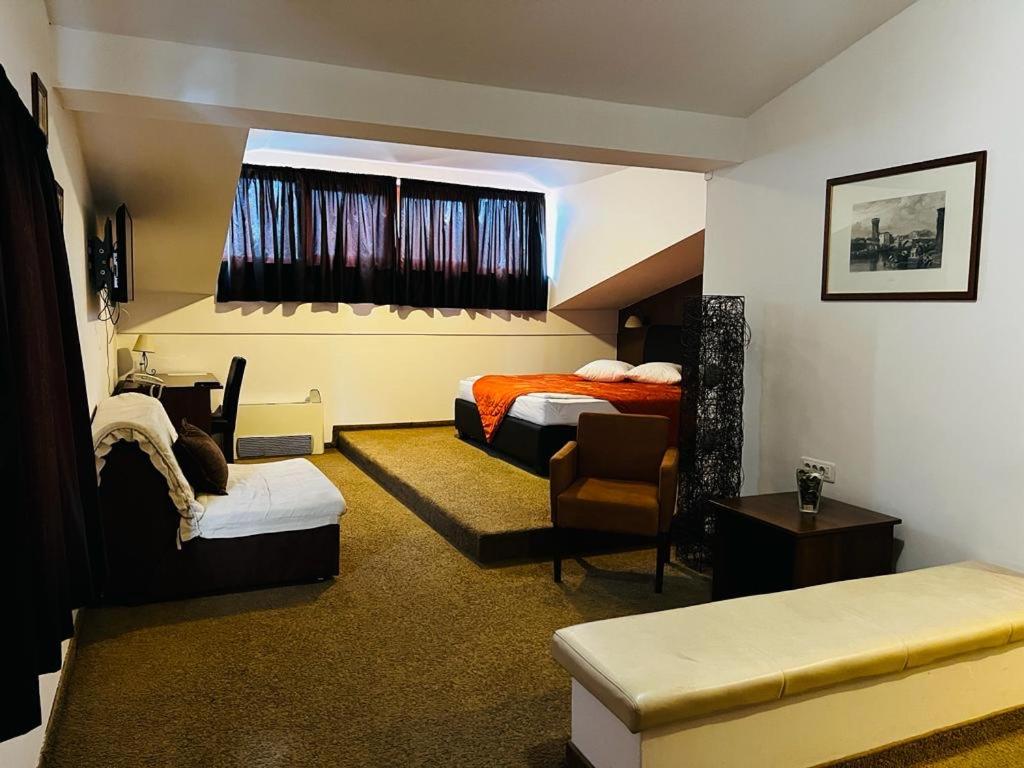 a hotel room with two beds and a chair at Stara Ada Banja Luka in Banja Luka