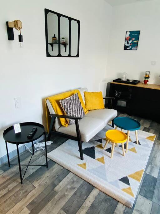 un salon avec un canapé et deux tables dans l'établissement Appartement de charme 1er etage, à Saint-Samson-sur-Rance