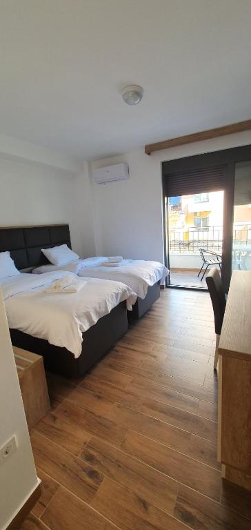 two beds in a room with a wooden floor at Apartment Verde in Bar