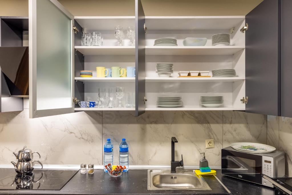 a kitchen with white cabinets and a sink at BayMari Suites Plus Florya in Istanbul