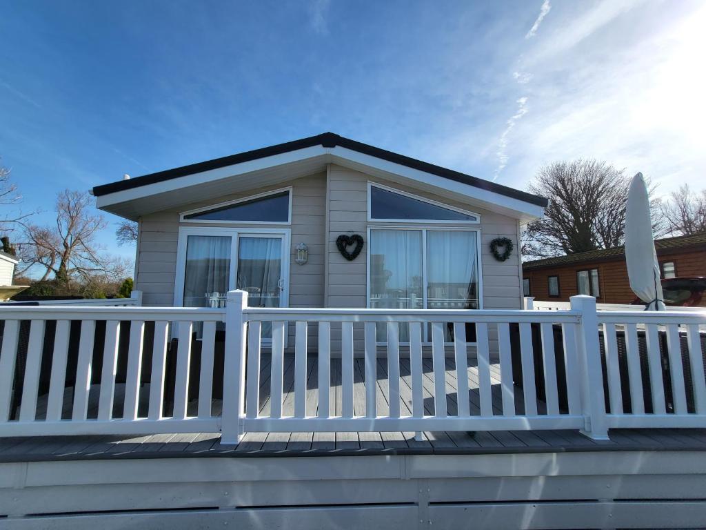a small house with a white fence at Idyllic Lakeview Lodge in Chichester