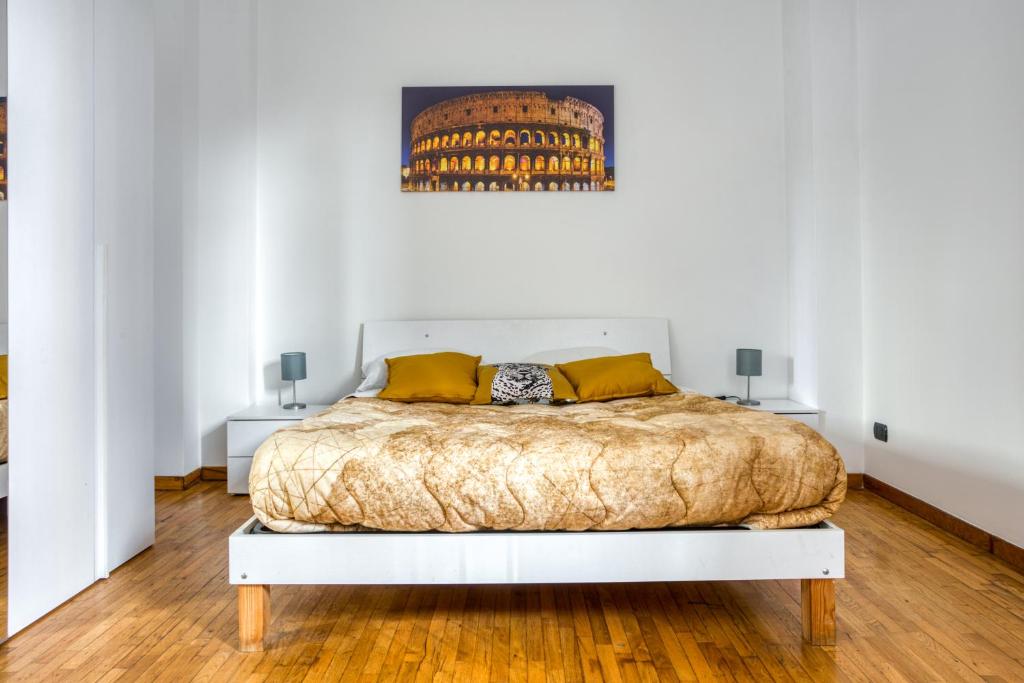 ローマにあるTIBURTINA Apartmentの白いベッドルーム(大型ベッド1台、黄色い枕付)