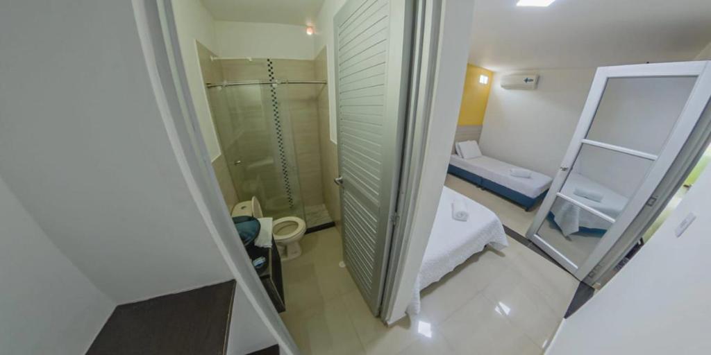 uma pequena casa de banho com um chuveiro e um espelho. em Hotel River Suite em Letícia