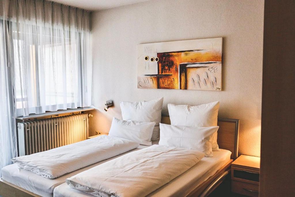 Un dormitorio con una cama con almohadas blancas y una ventana en Land.Wein.Gut Pension, en Klingenmünster