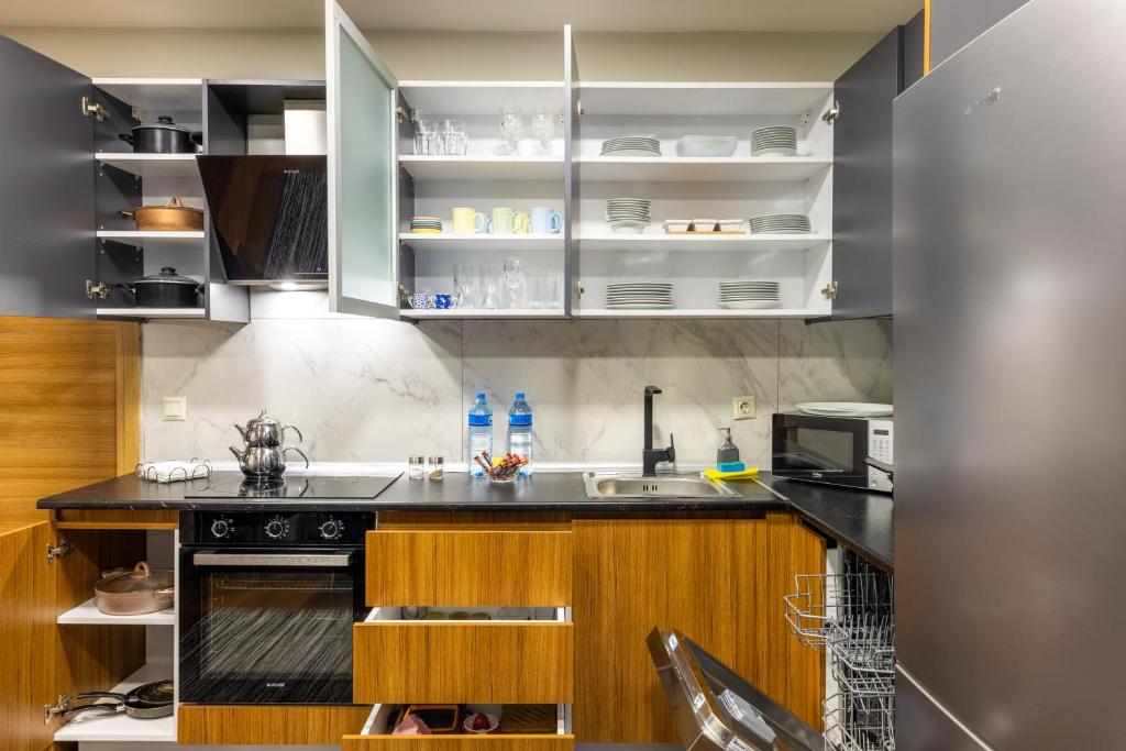 a kitchen with a black counter top and wooden cabinets at BayMari Suites Plus Florya in Istanbul