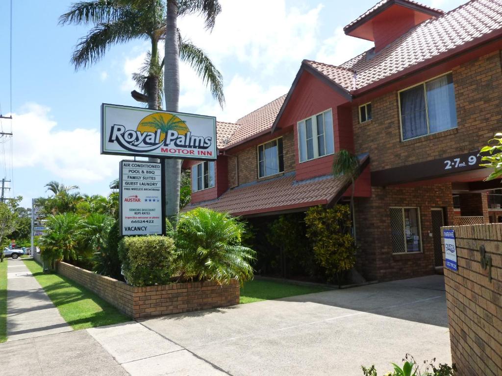 um sinal imobiliário em frente a uma casa em Royal Palms Motor Inn em Coffs Harbour