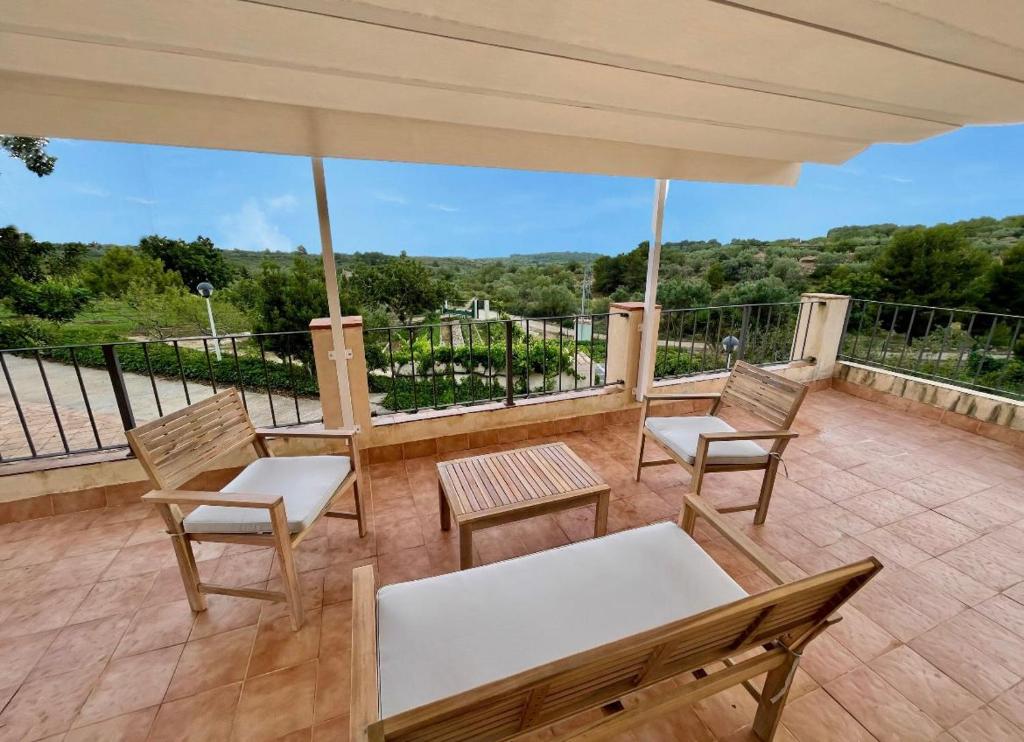 une terrasse avec des chaises, une table et un parasol dans l'établissement Alojamiento Can Alegre, à El Perelló