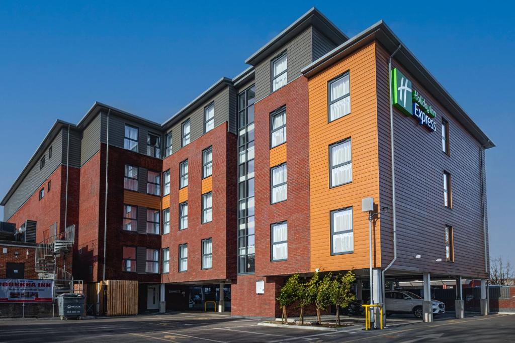 an apartment building with an orange and black at Holiday Inn Express - Fleet, an IHG Hotel in Fleet