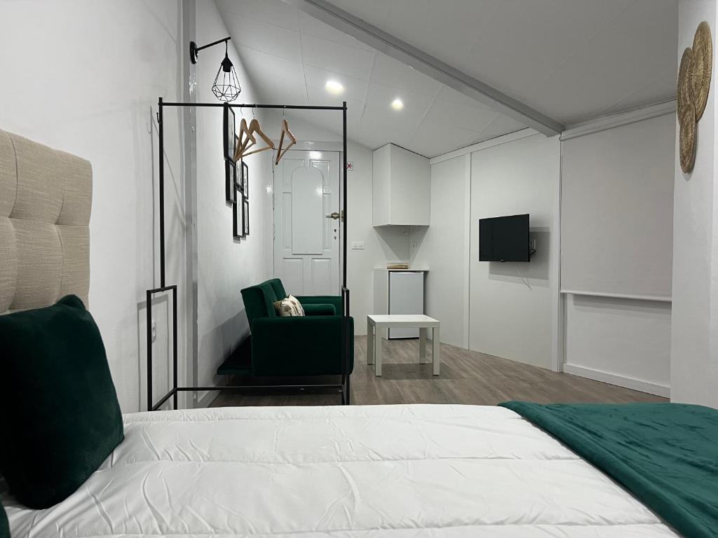 1 dormitorio con 1 cama y 1 silla verde en Apartamento en Cieza AM, en Cieza