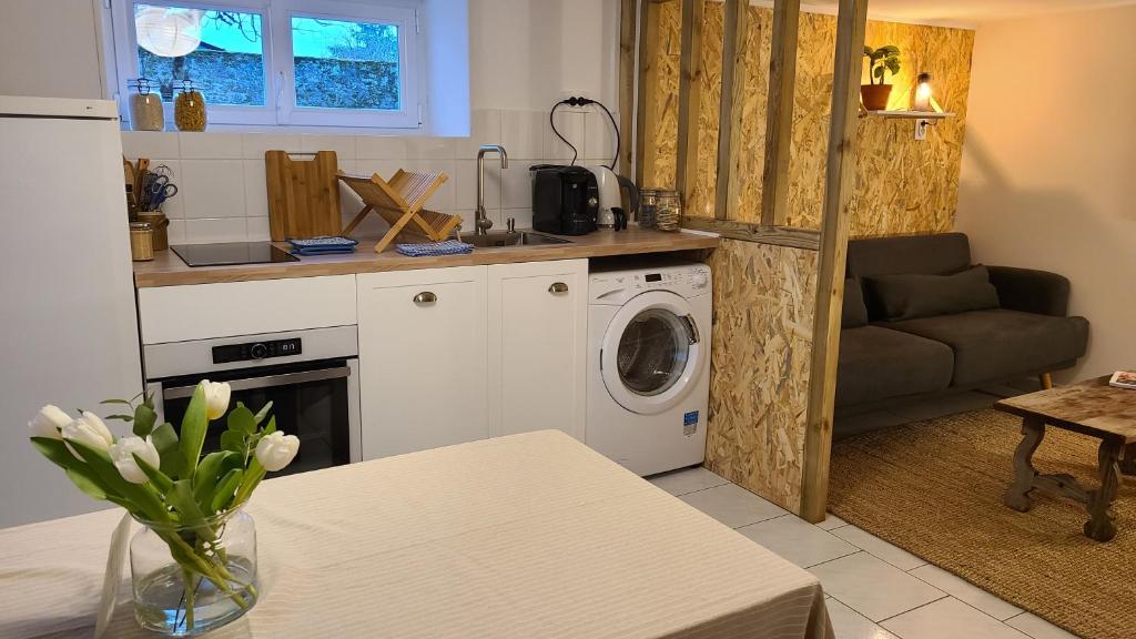 una cucina con lavatrice in una cucina con tavolo di Le Petit Lavoir - Maison Cosy à Mayet a Mayet