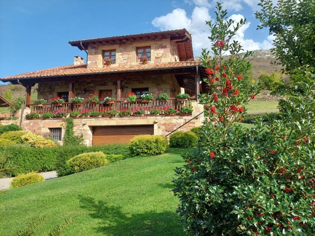 una casa con un balcón con flores rojas. en Casa Cordancas, en Cicera
