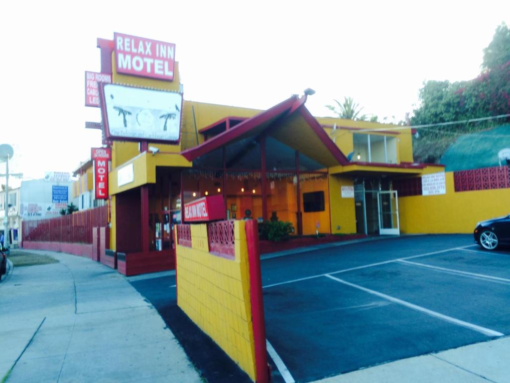 a building with a motel sign in a parking lot at Relax Inn in Los Angeles