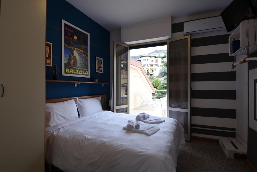 a bedroom with a bed and a large window at Residence Corallo in Alassio