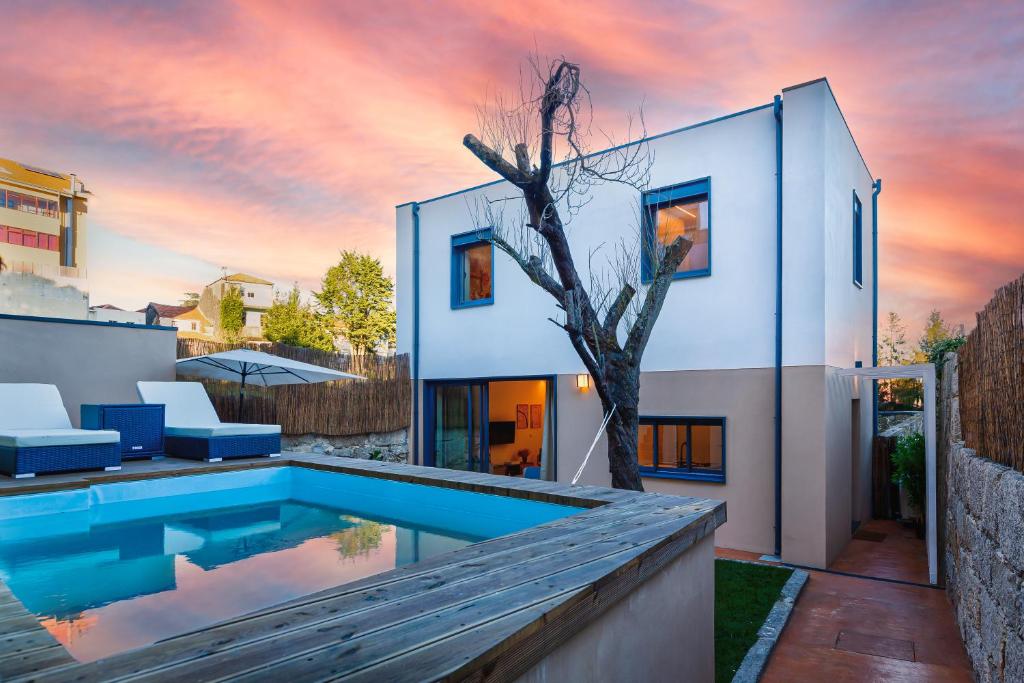 a house with a swimming pool and a tree at Design Antas Home in Porto