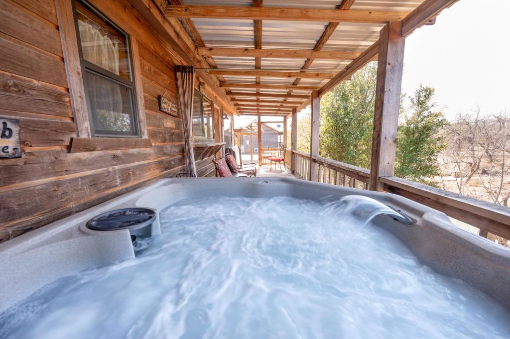 a jacuzzi tub on the porch of a cabin at City on a Hill at Spring Creek in Fredericksburg