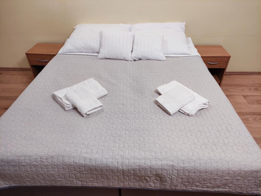 een bed met witte handdoeken en kussens erop bij Apartament Pod Lasem in Police
