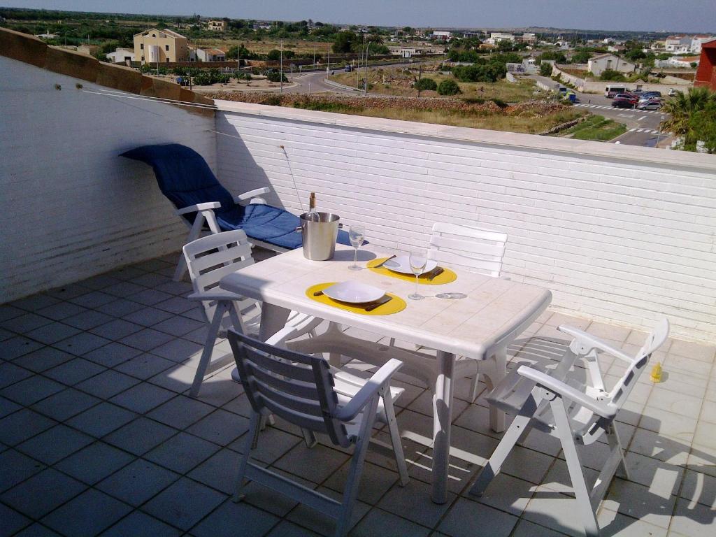 una mesa blanca y sillas en el techo en Apart duplex Cala Busquets, en Ciutadella