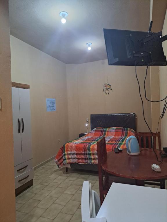 a bedroom with a bed and a table with a table at Hummingbird Hostel in Ciudad del Este