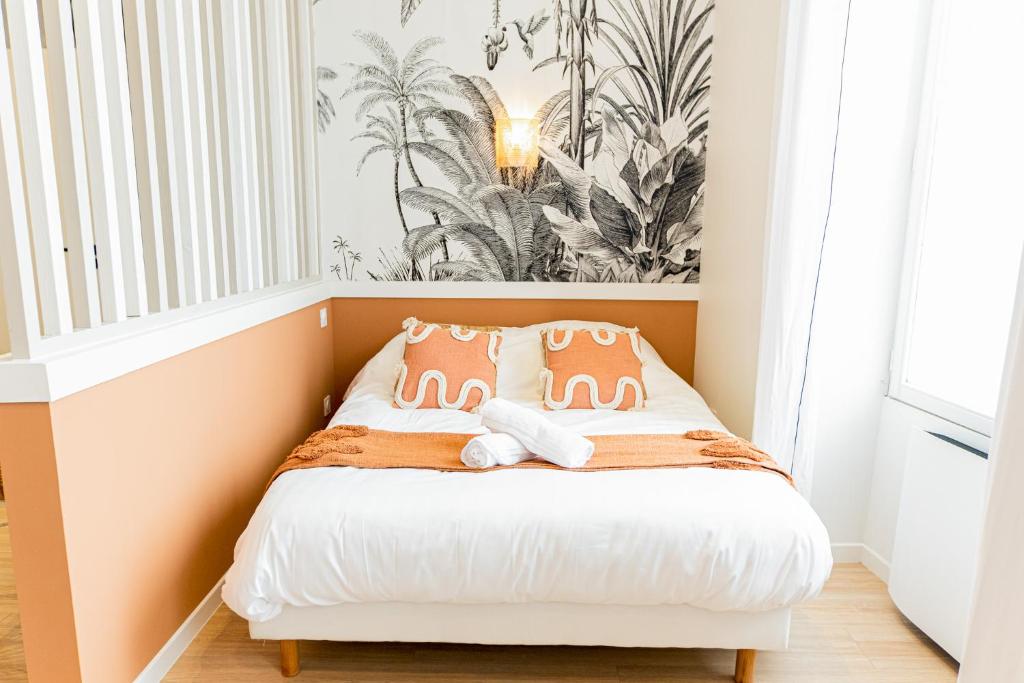 małą sypialnię z łóżkiem z pomarańczowymi poduszkami w obiekcie Le Terracotta - Superbe appartement - Hyper centre w mieście Le Mans
