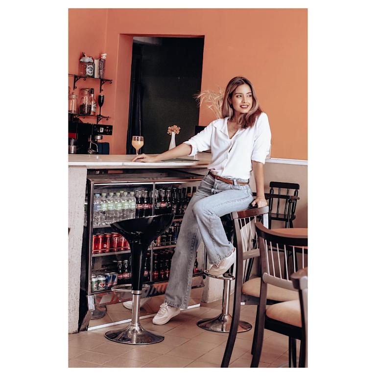 a woman sitting at a bar with a glass of wine at Hotel Ibiá in Montenegro