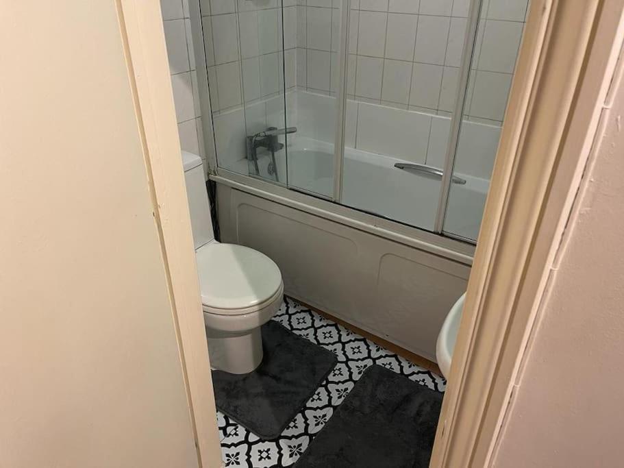 een badkamer met een toilet, een bad en een douche bij Cosy Studio West Hampstead in Londen