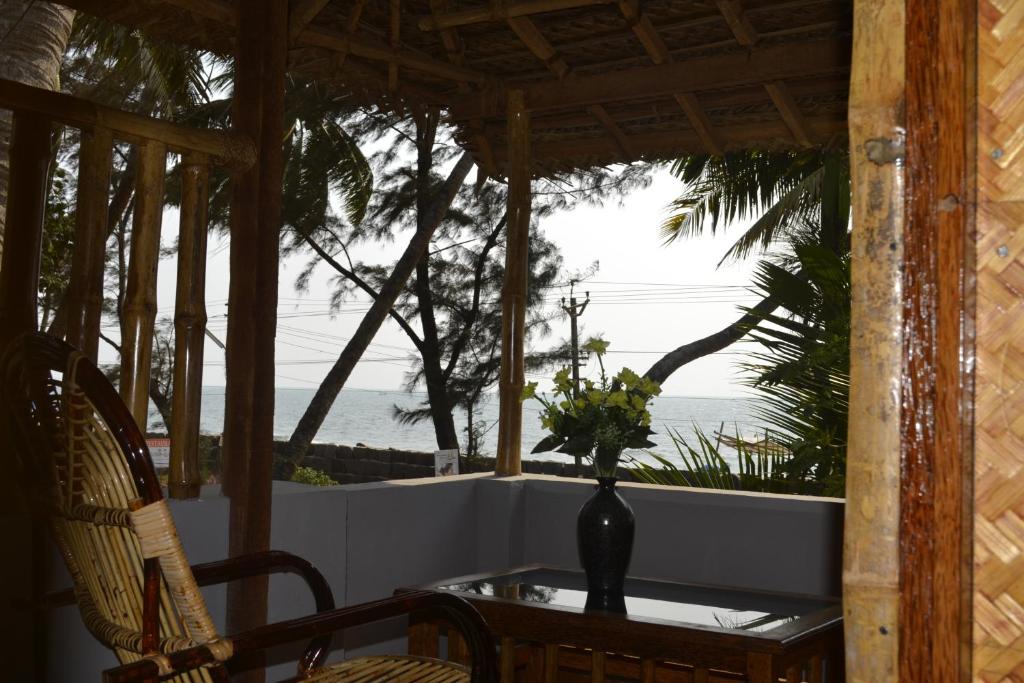 a vase with flowers on a table on a porch at Sajeev Home Stay in Cherai Beach