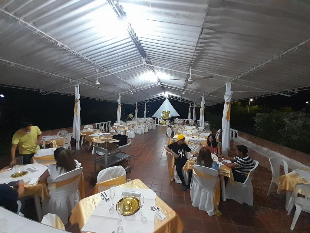 a group of people sitting at tables in a tent at Hotel Campestre CENVATURS in Ricaurte