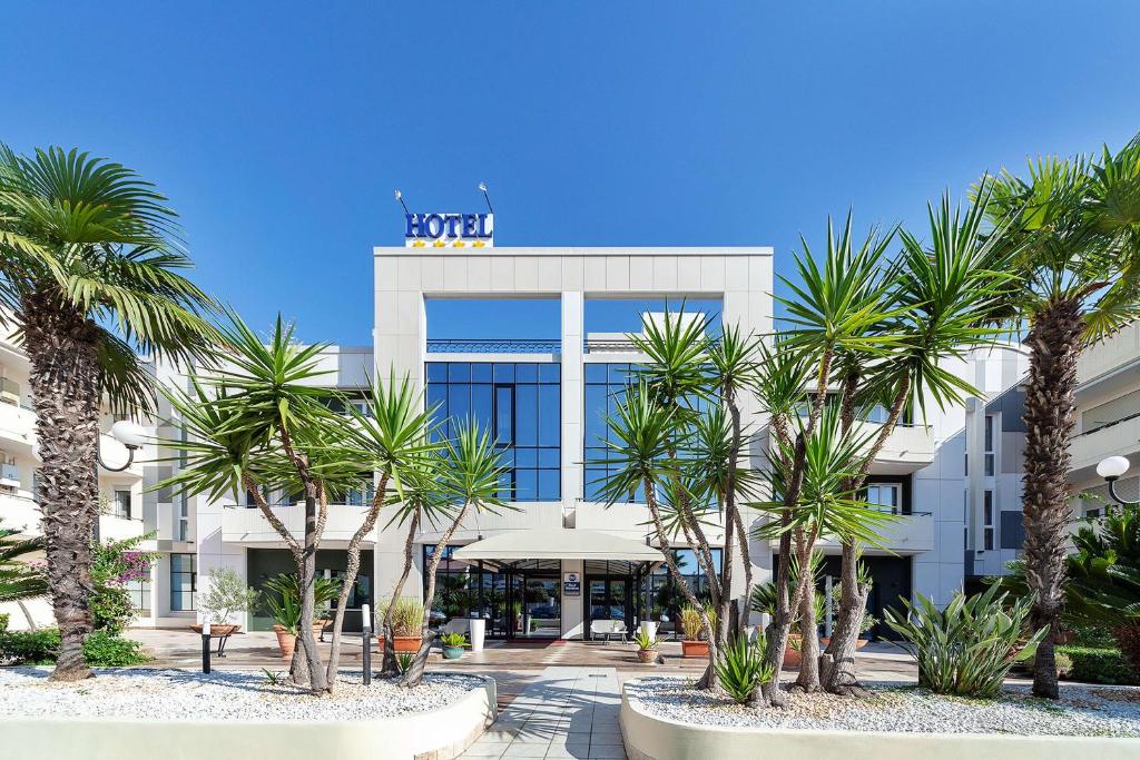 a building with palm trees in front of it at Best Western Hotel Imperiale in Nova Siri Marina