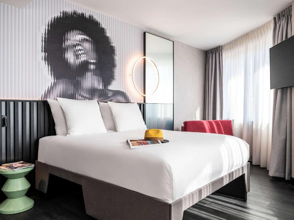 een slaapkamer met een bed met een schilderij aan de muur bij Tribe Amsterdam City in Amsterdam