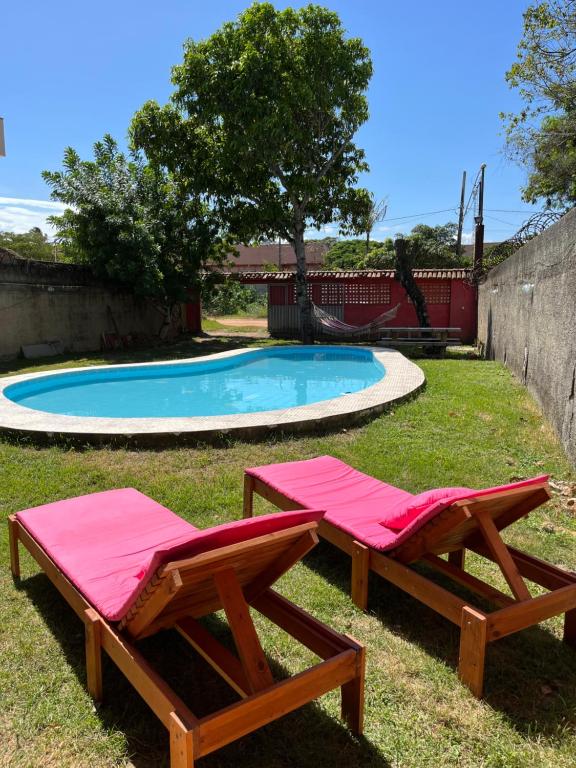 dos mesas de picnic junto a una piscina en Setiba Beach House, en Guarapari