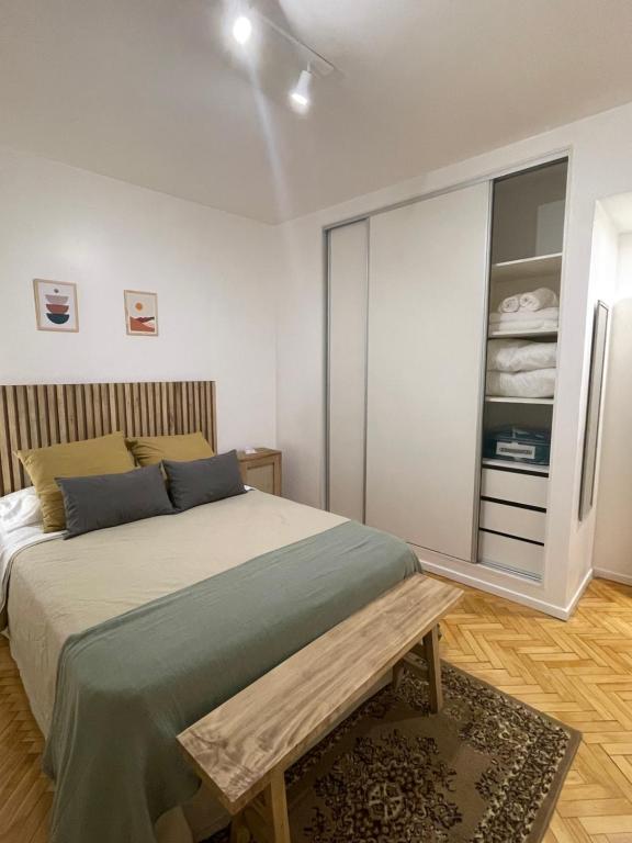 Un dormitorio con una cama con un banco. en Julia's House en Buenos Aires