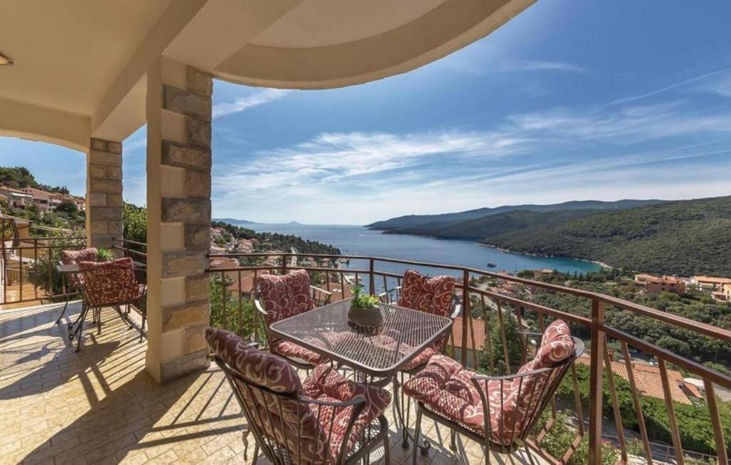 a balcony with a table and chairs and a view at Apartments with a parking space Rabac, Labin - 7441 in Rabac