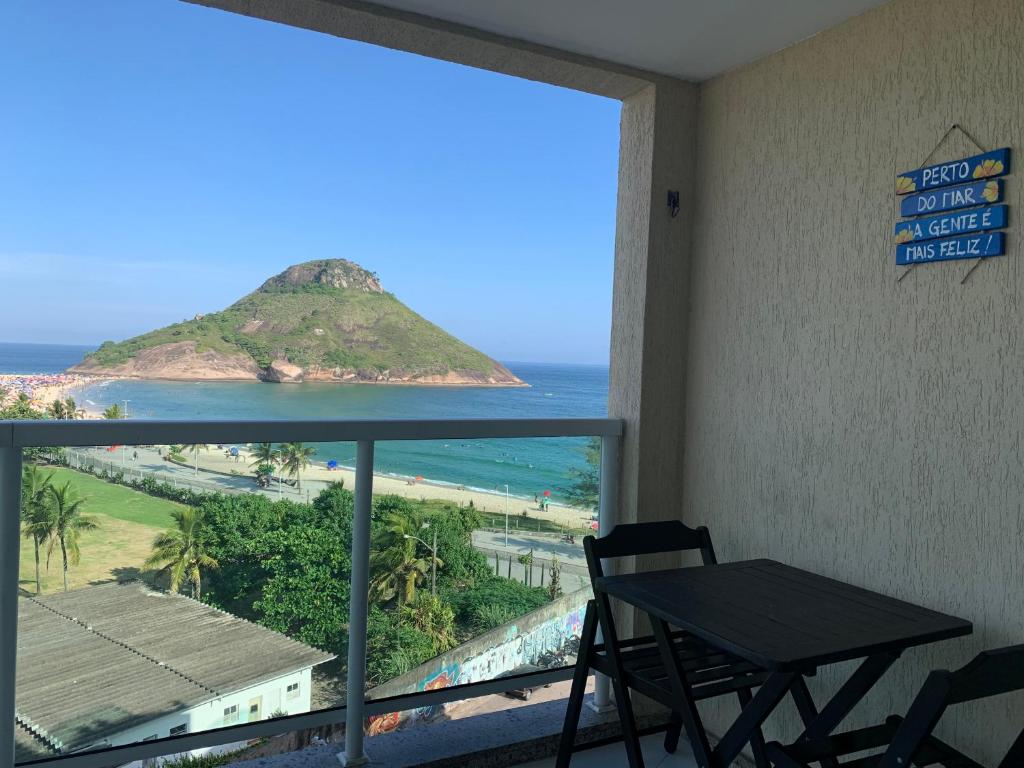 Habitación con mesa y vistas al océano en Flat na Praia do Pontal com vista deslumbrante - Villa del Sol Residences, en Río de Janeiro
