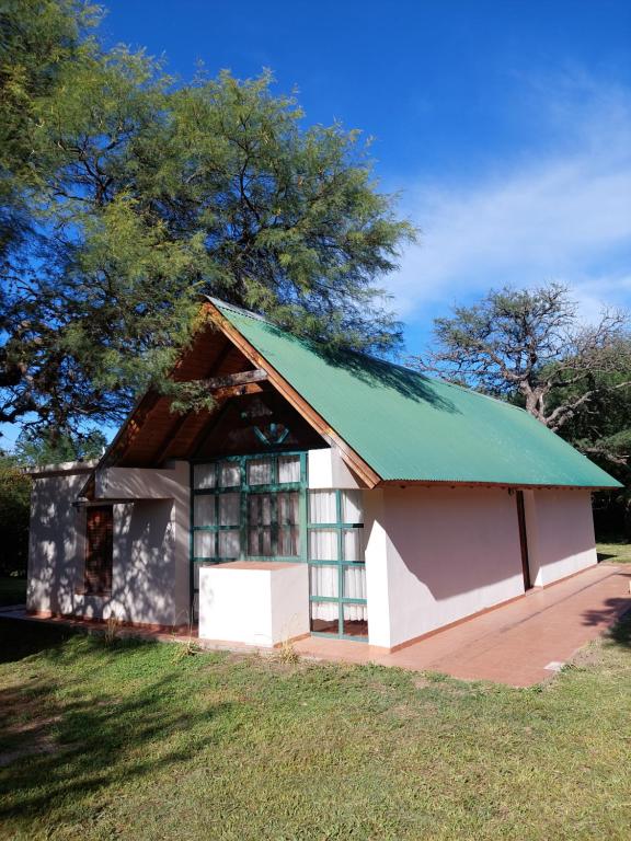 un pequeño edificio blanco con techo verde en La Casita de Nono en Nono