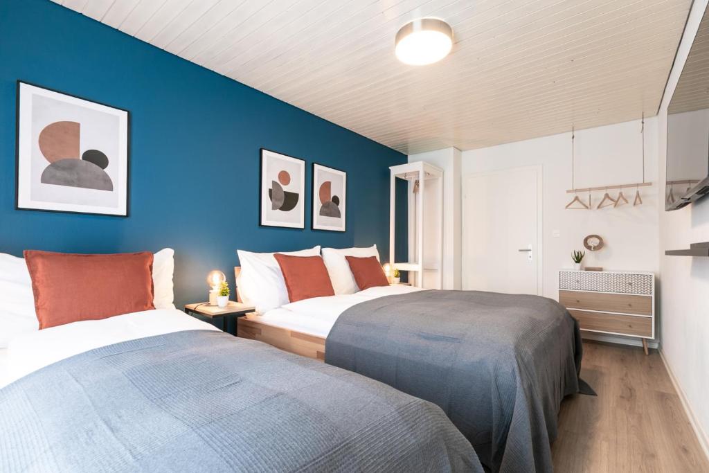 Spirit Apartments Zentral mit gratis Parkplatz في لوتزيرن: سريرين في غرفة نوم بجدران زرقاء