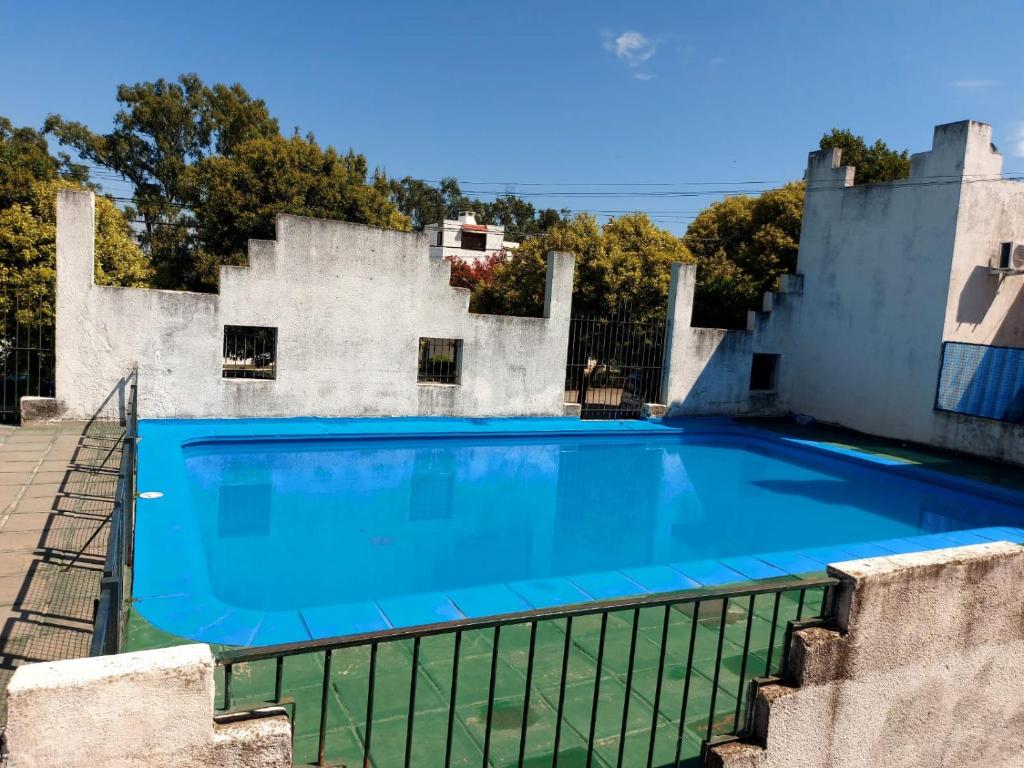 una gran piscina azul frente a un edificio en Castillo Del Lago - Carlos Paz - D24 en Villa Carlos Paz