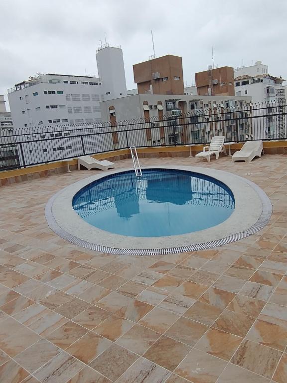 una piscina sul tetto di un edificio di Praia de Pitangueiras, flat, do lado da praia sem roupas de cama a Guarujá