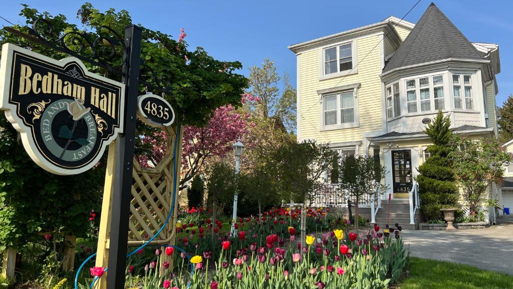 un cartello stradale di fronte a una casa con fiori di Bedham Hall B&B a Niagara Falls