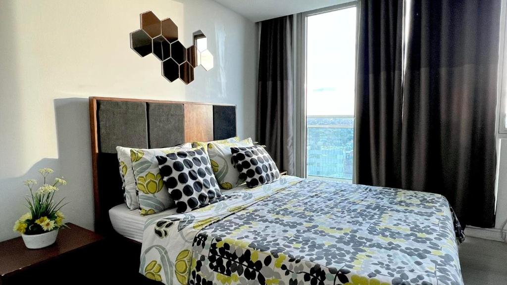 - une chambre avec un lit et une grande fenêtre dans l'établissement Azure Peaceful and Beachy Staycation, à Manille