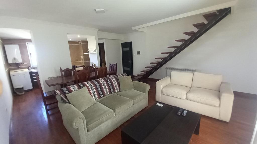 sala de estar con sofá, silla y escalera en Departamento Vicente López - Salta en Salta