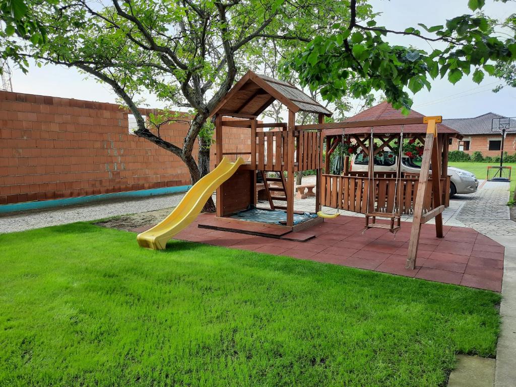 a playground with a slide and a gazebo at Sissy Vendégház in Mórahalom