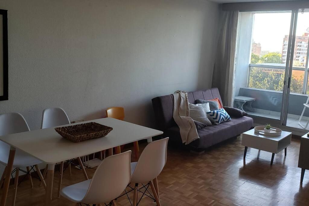 a living room with a table and chairs and a couch at Frente a Terminal Tres Cruces. in Montevideo