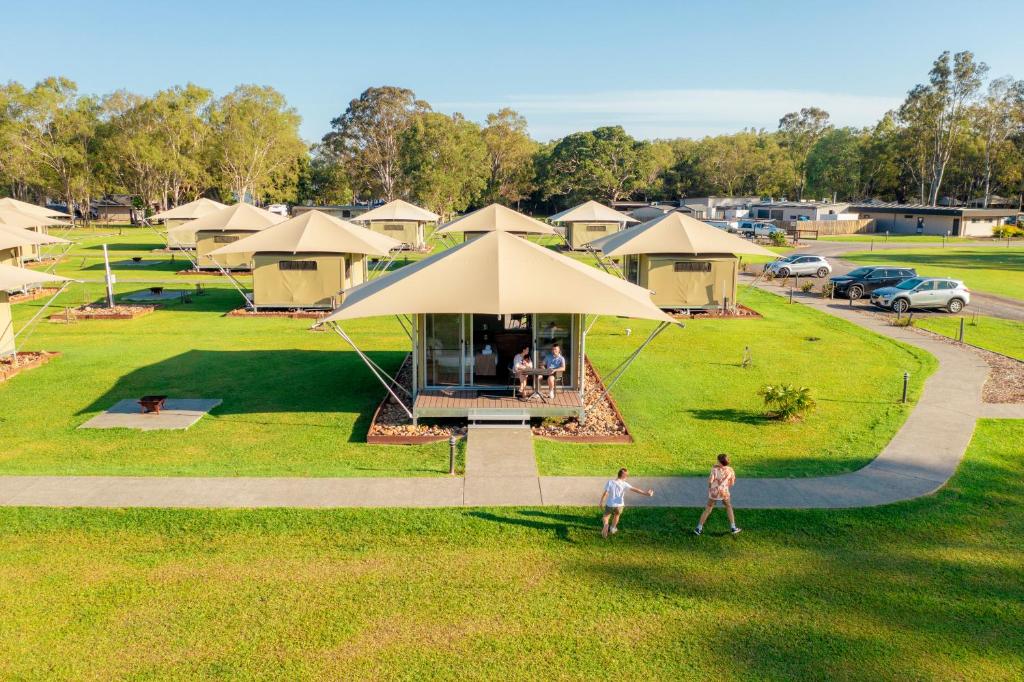 2 personnes debout devant un groupe de tentes dans l'établissement Habitat Noosa, à Cootharaba