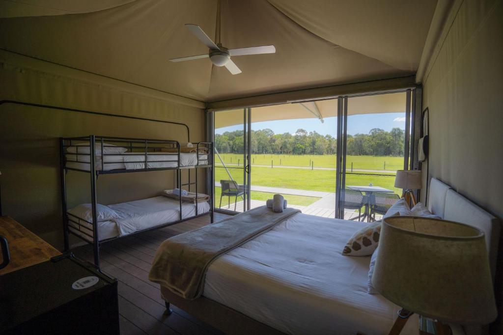 una camera con letto, ventilatore e finestra di Habitat Noosa a Cootharaba